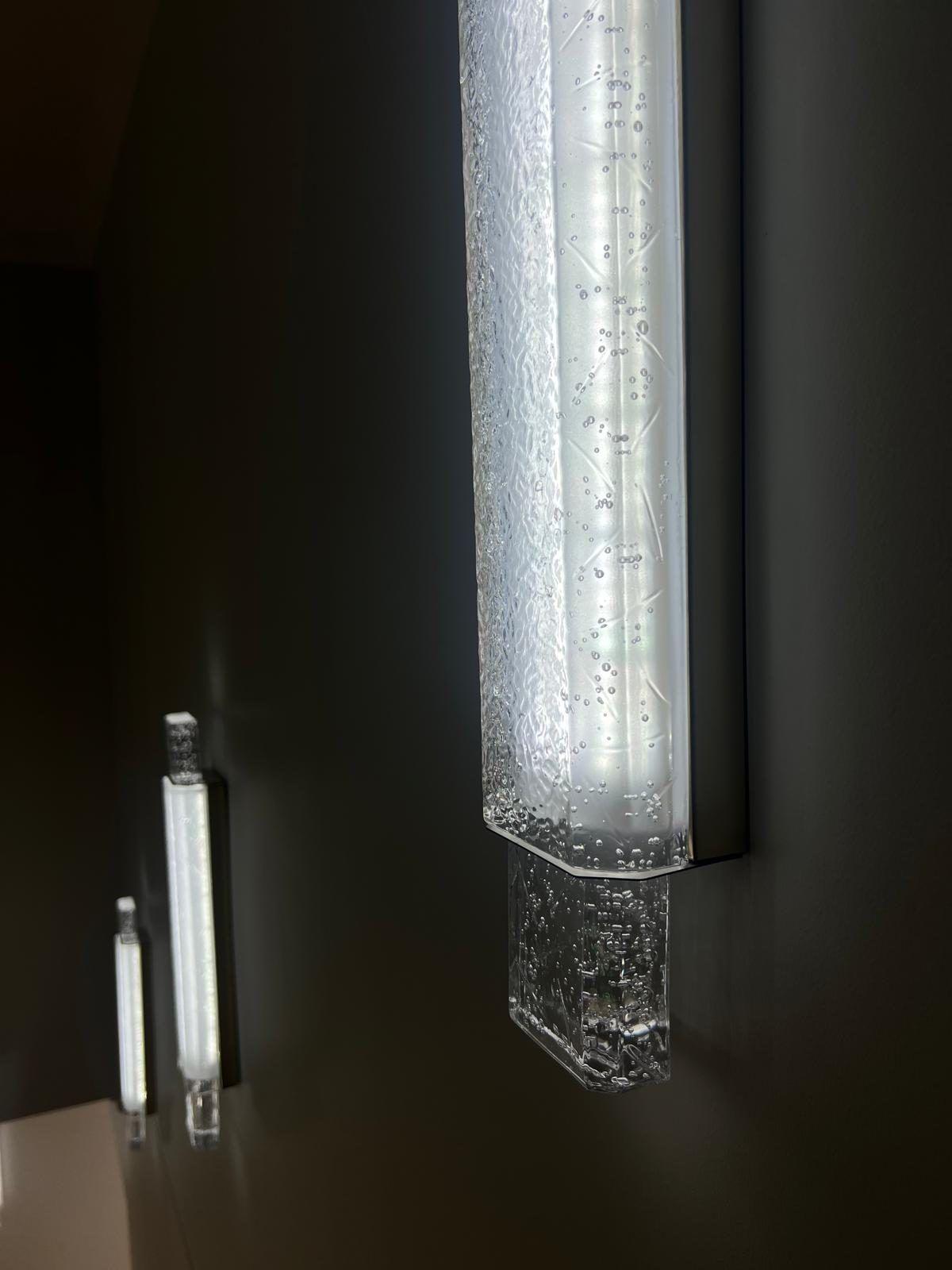 A fluted crystal light fitting against a dark wall.